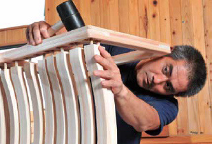 椅子の座面と脚を組み立てる作業。